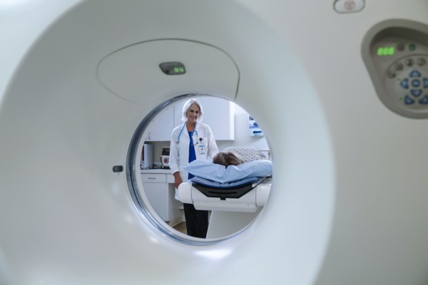 Caucasian doctor comforting patient near scanner