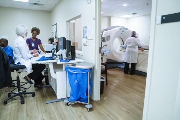 Doctor and technician talking near scanner