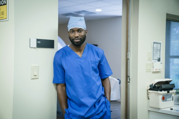 Portrait of a black nurse leaning in doorway
