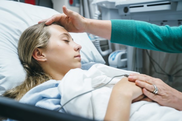 Caucasian doctor comforting patient in hospital bed