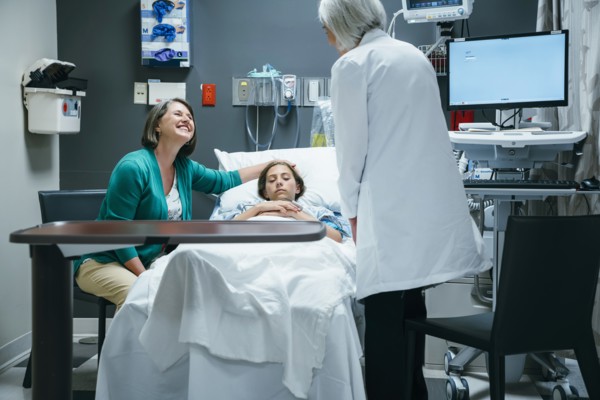 Caucasian doctor talking to mother and daughter in hospital