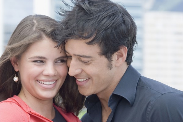Hispanic couple hugging outdoors