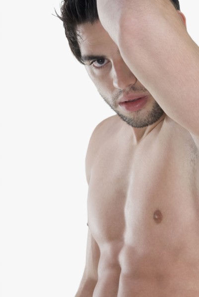 Bare-chested Hispanic man holding arm up