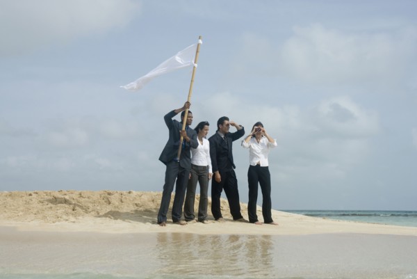 Multi-ethnic businesspeople with flag at beach