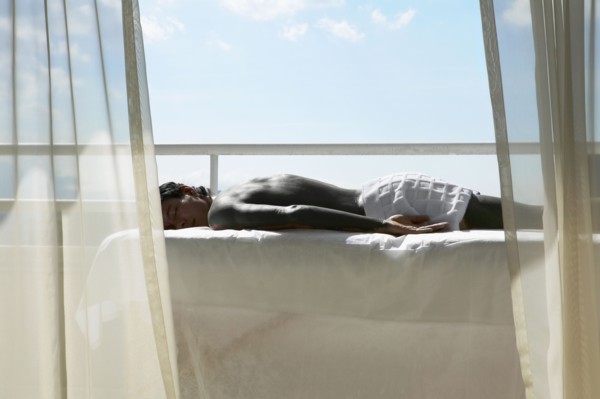 Man laying on massage table on balcony
