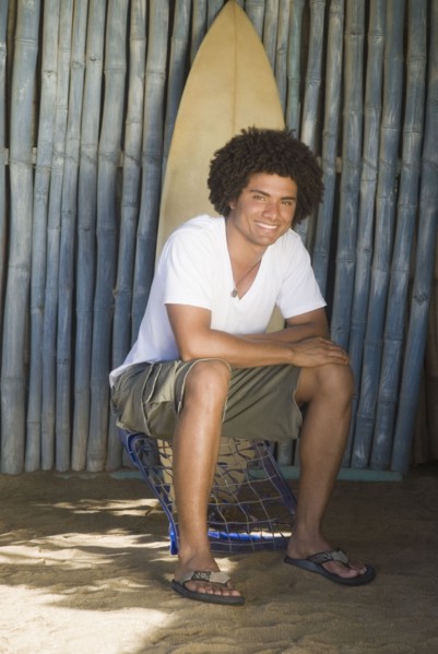 African man outdoors with surfboard