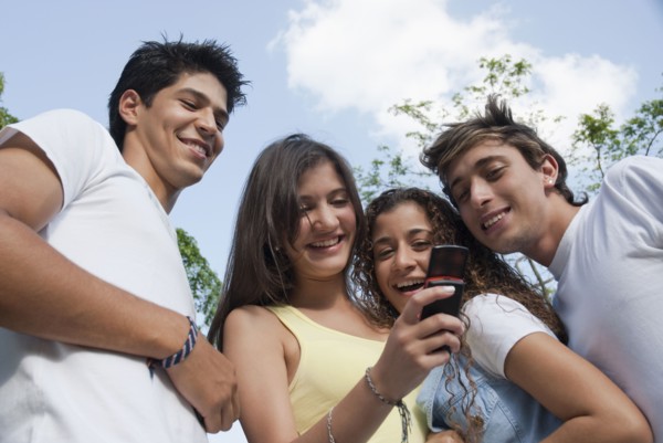 Hispanic friends looking at cell phone together