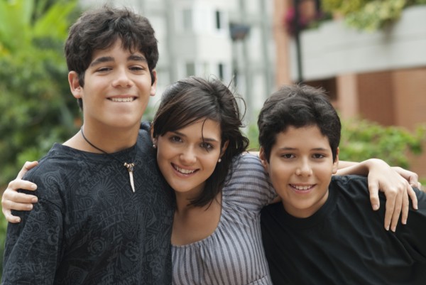 Hispanic mother and sons hugging