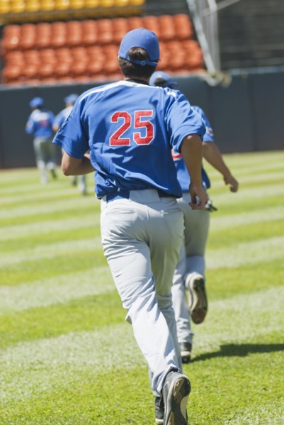 Hispanic baseball player running on field