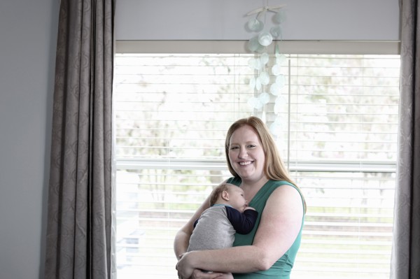 Mother holding baby son at window
