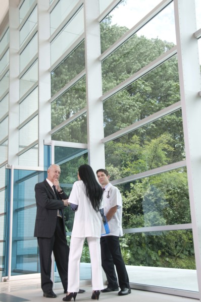 Hispanic businessman talking to doctor in lobby