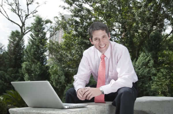 Hispanic businessman using laptop outdoors