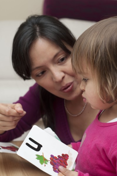 Hispanic mother teaching daughter alphabet
