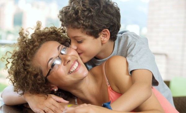Hispanic boy kissing mother