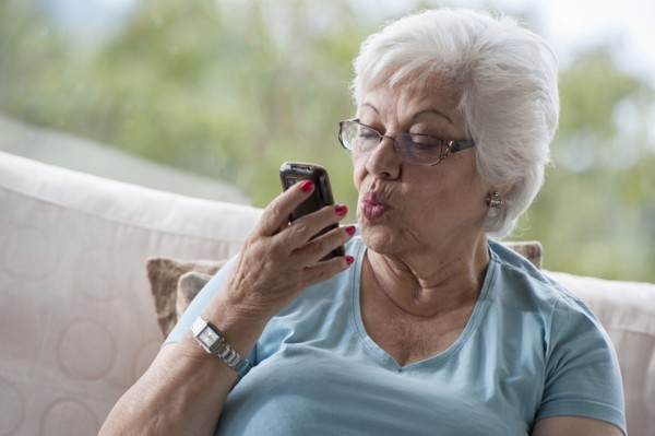 Hispanic woman making kissy face at cell phone