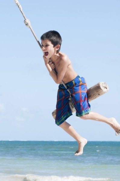 Hispanic boy playing on swing outdoors