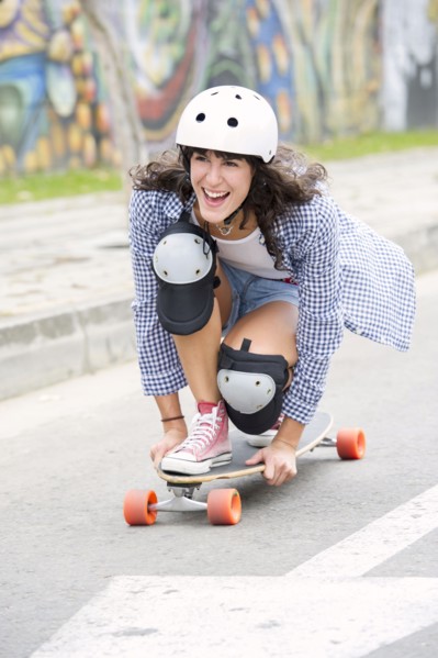 Hispanic woman riding skateboard