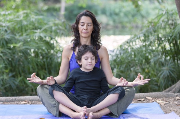 Hispanic mother and son practicing yoga