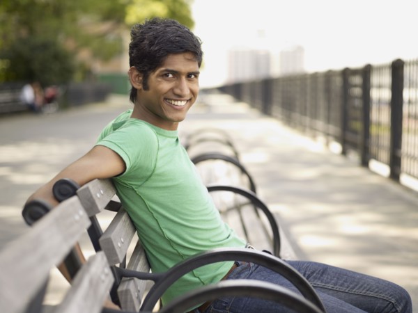 Indian man relaxing on park bench