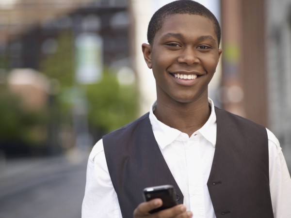 African man text messaging on cell phone