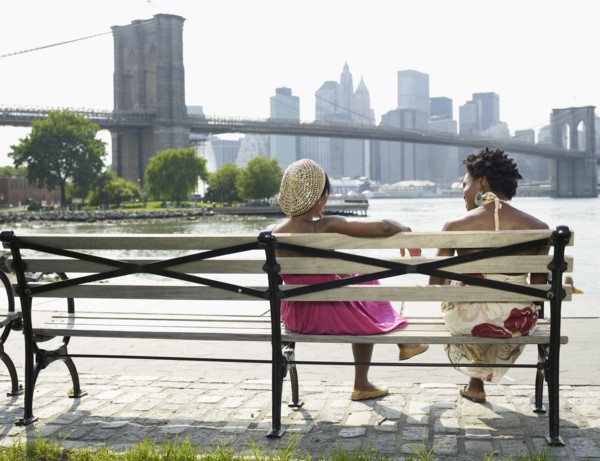 African women sitting on bench at urban waterfront