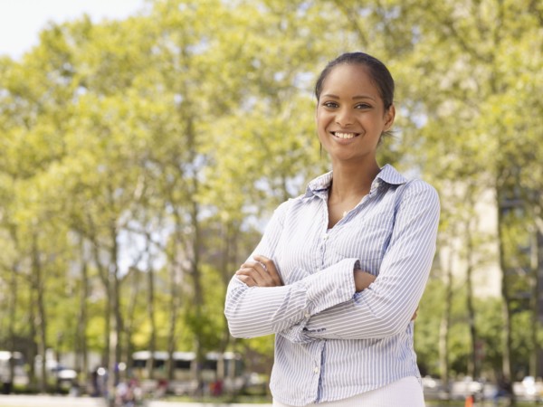 Mixed race woman with arms crossed in park