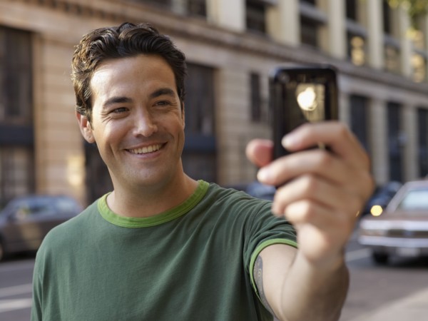 Man taking photograph with cell phone