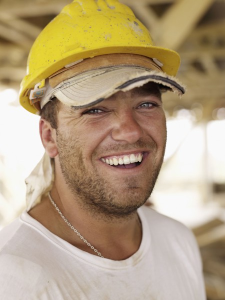Hispanic worker smiling on construction site