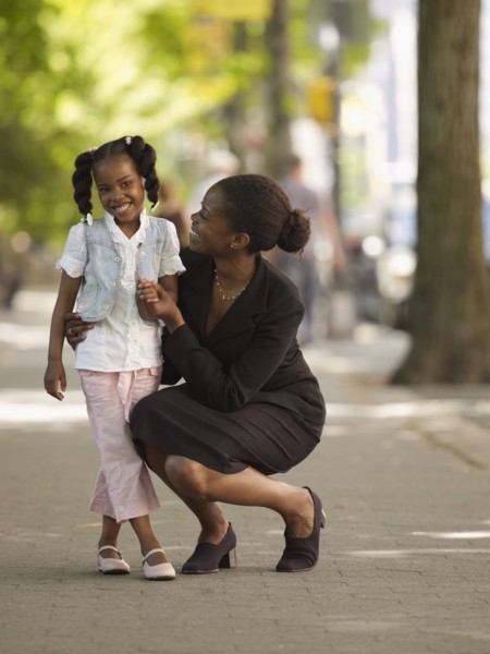 African businesswoman hugging girl