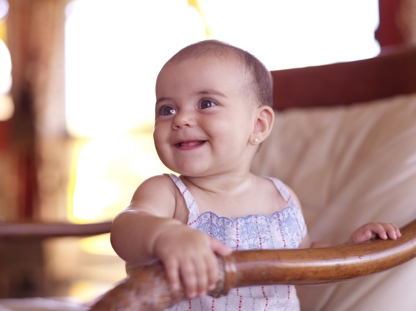 Hispanic baby girl sitting in chair
