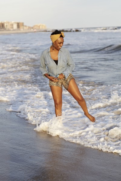 Black woman wading in ocean on beach