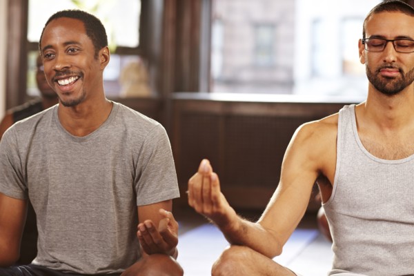 Men meditating in yoga class