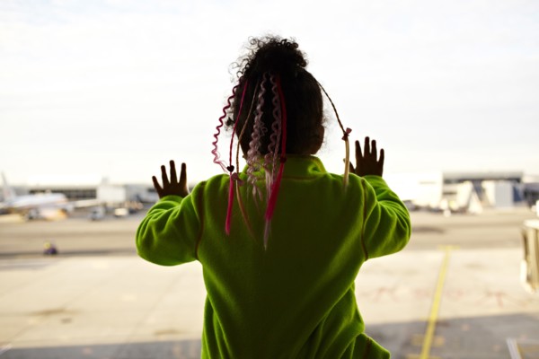 Mixed race girl looking out airport window