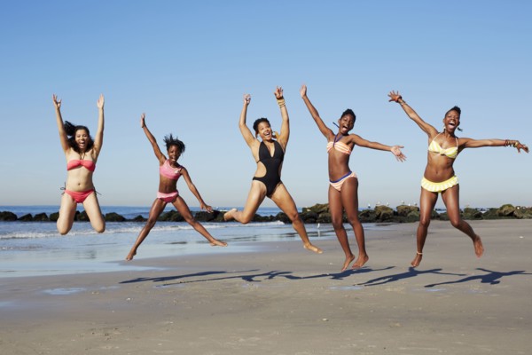 Women jumping for joy on beach