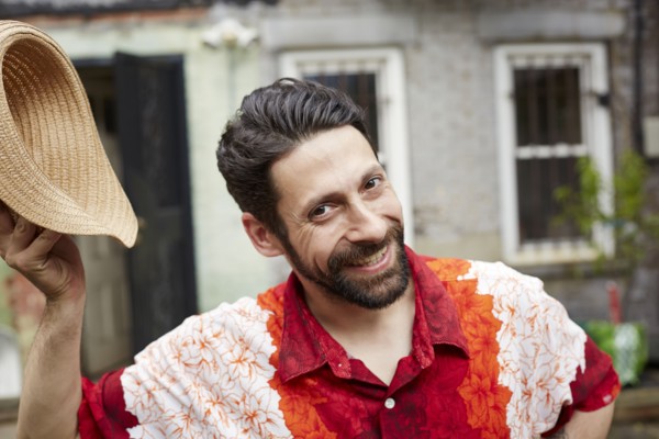 Caucasian man tipping straw hat in backyard