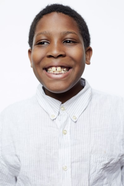 Close up of smiling boy wearing fully-buttoned shirt