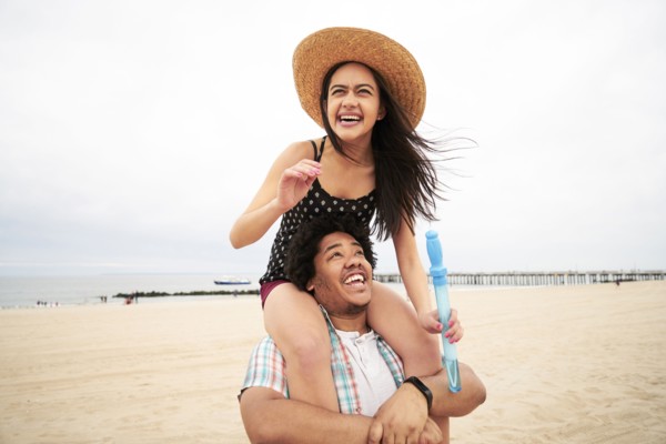 Man carrying woman on shoulders at beach