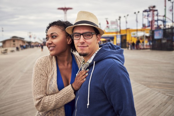 Couple standing on boardwalk at amusement park