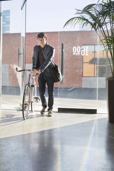 Korean businessman wheeling bicycle in office