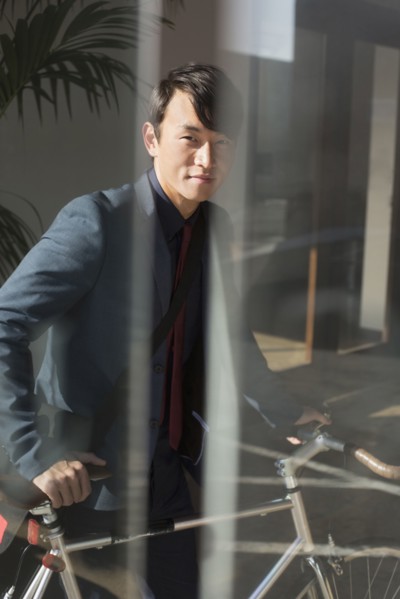 Korean businessman wheeling bicycle in office