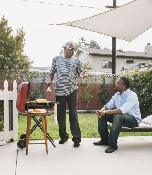 African American father and son talking at barbecue