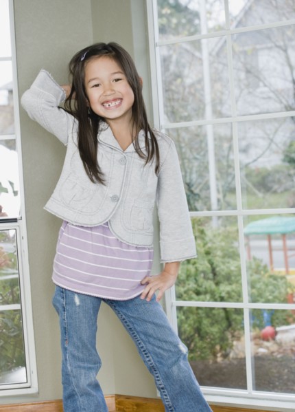 Mixed Race girl posing next to window