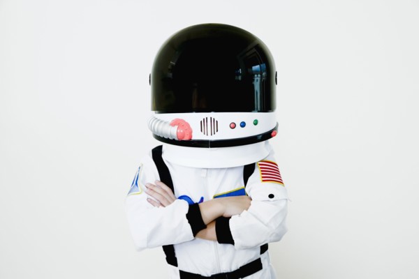 Mixed race boy in astronaut costume