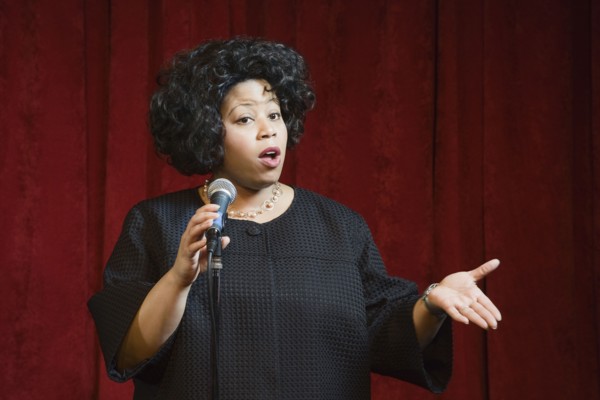 African woman singing on stage