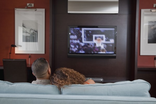Couple watching basketball game on television in living room