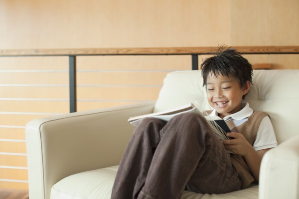 Mixed race boy reading book in armchair