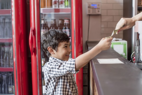 Mixed race boy buying food in restaurant