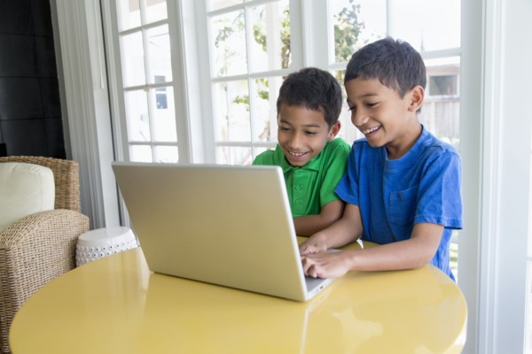 Hispanic boys using laptop