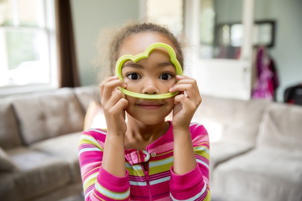 Mixed race girl playing with cookie cutter