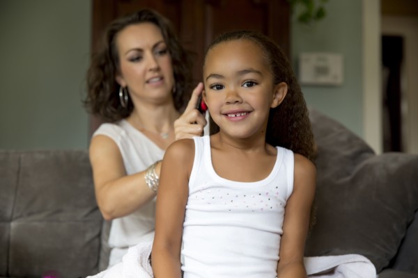 Mother fixing daughter's hair